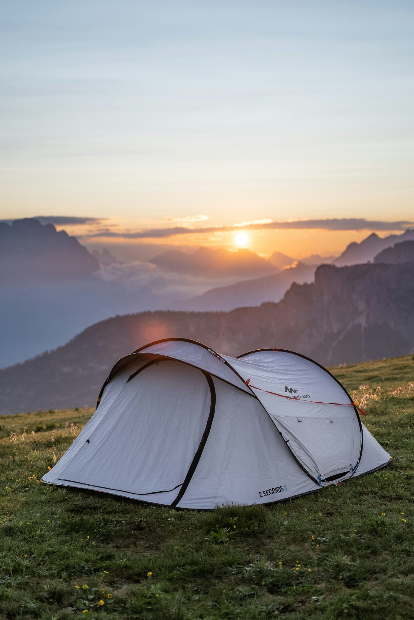 a tent on a mountain top surrounded by beautiful skies and mountains